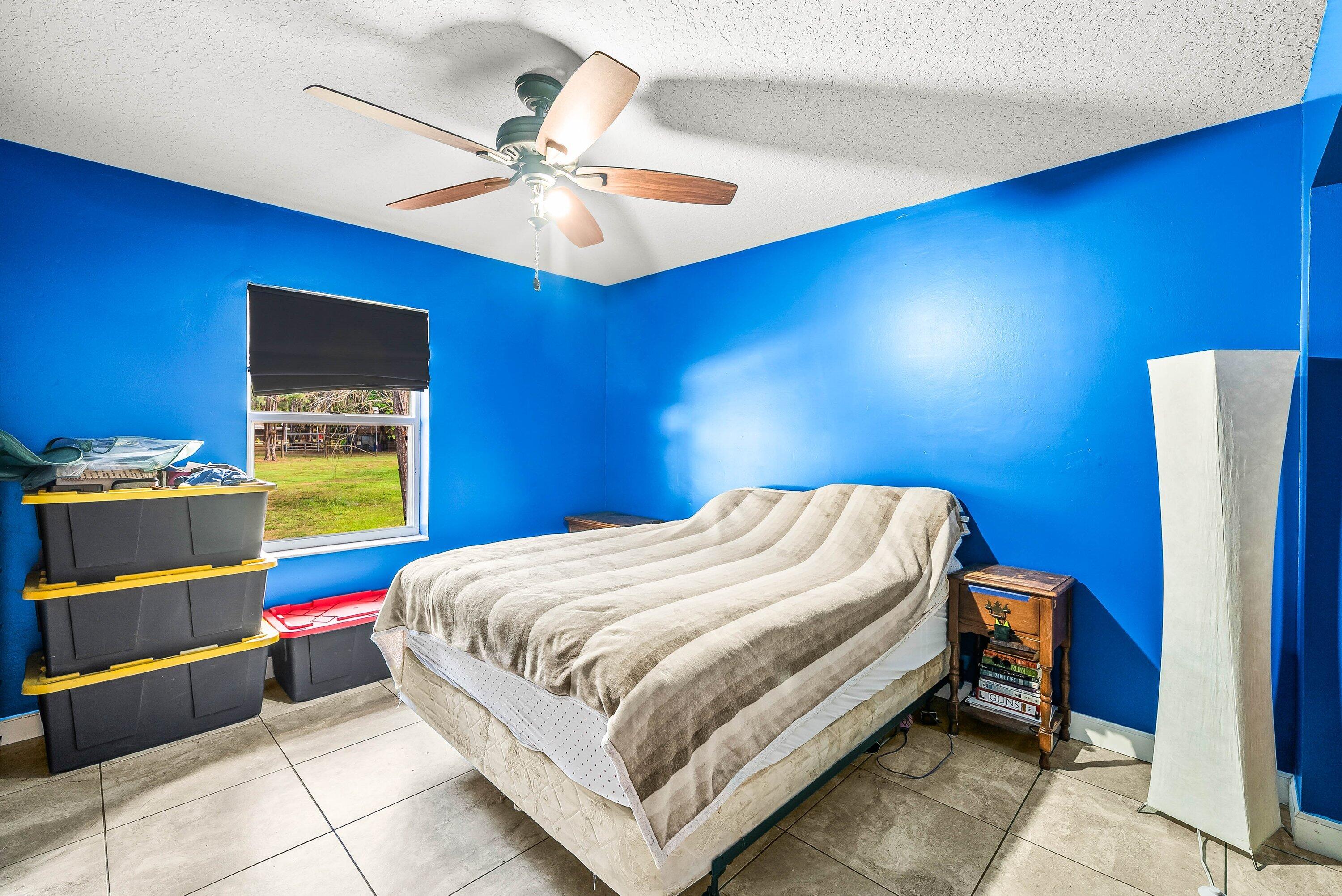 2195 F Road Loxahatchee Groves, FL 33470 - Photo 16 of 54 a bedroom with a bed and a chandelier