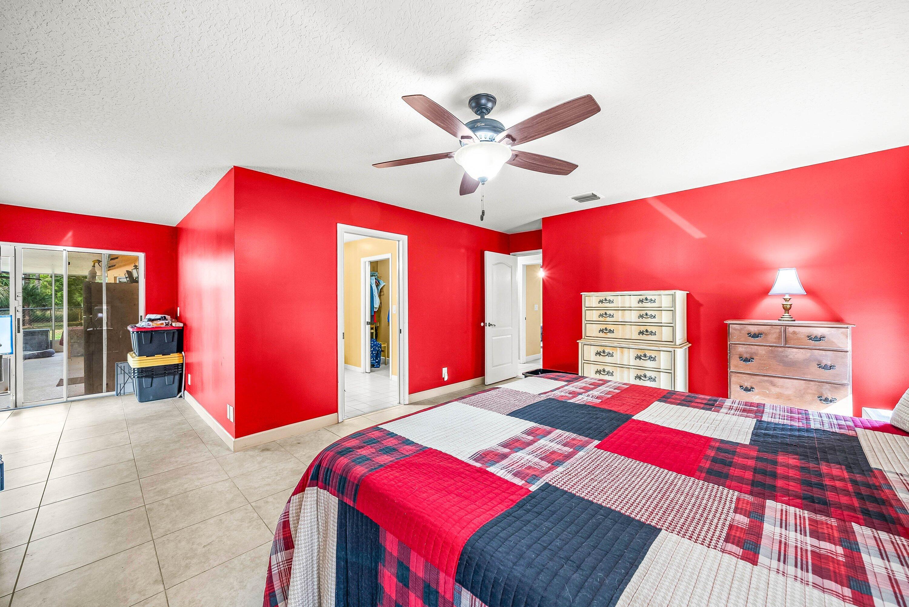 2195 F Road Loxahatchee Groves, FL 33470 - Photo 18 of 54 a bedroom with a bed and a chandelier