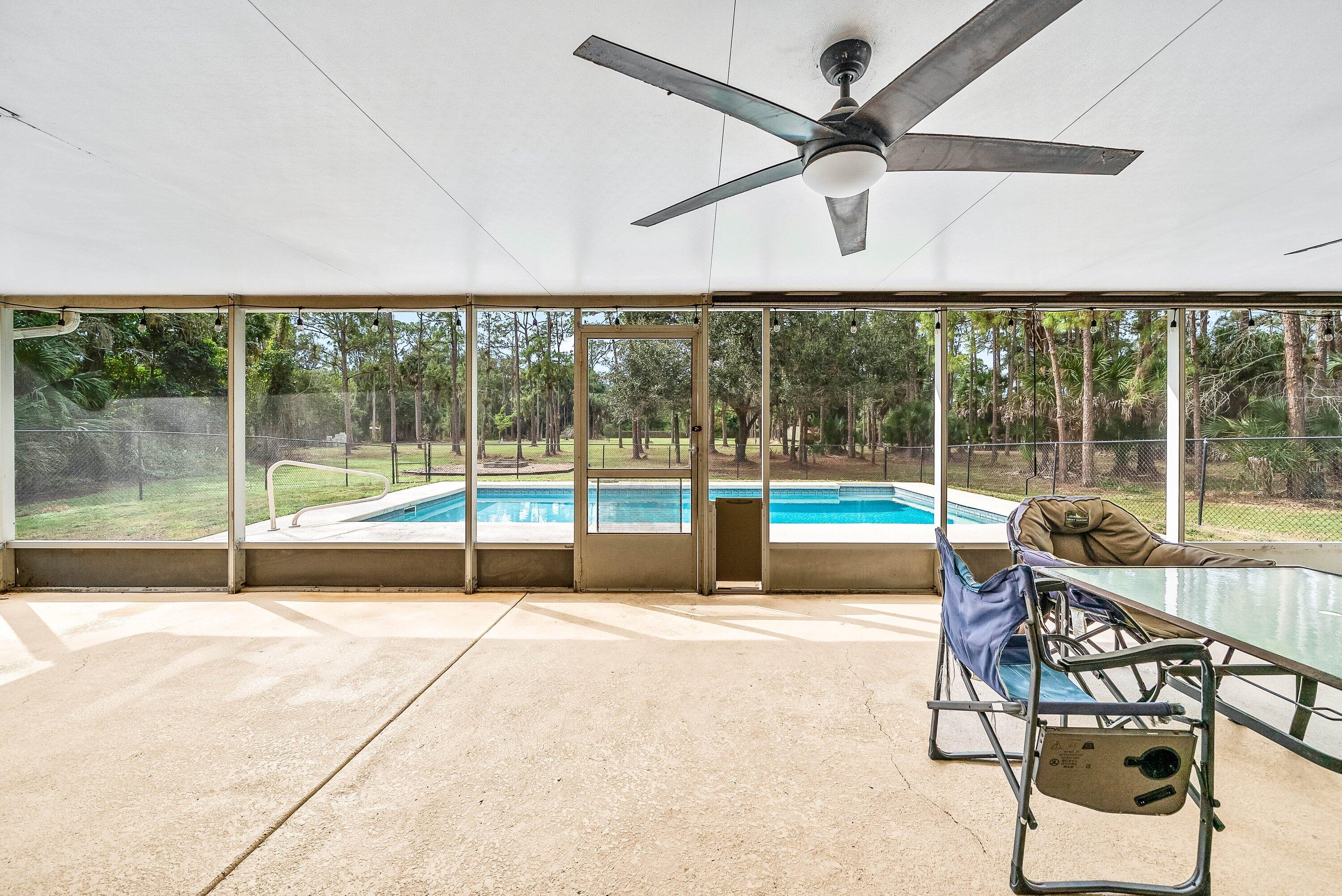 2195 F Road Loxahatchee Groves, FL 33470 - Photo 21 of 54 a swimming pool with lawn chairs and couches
