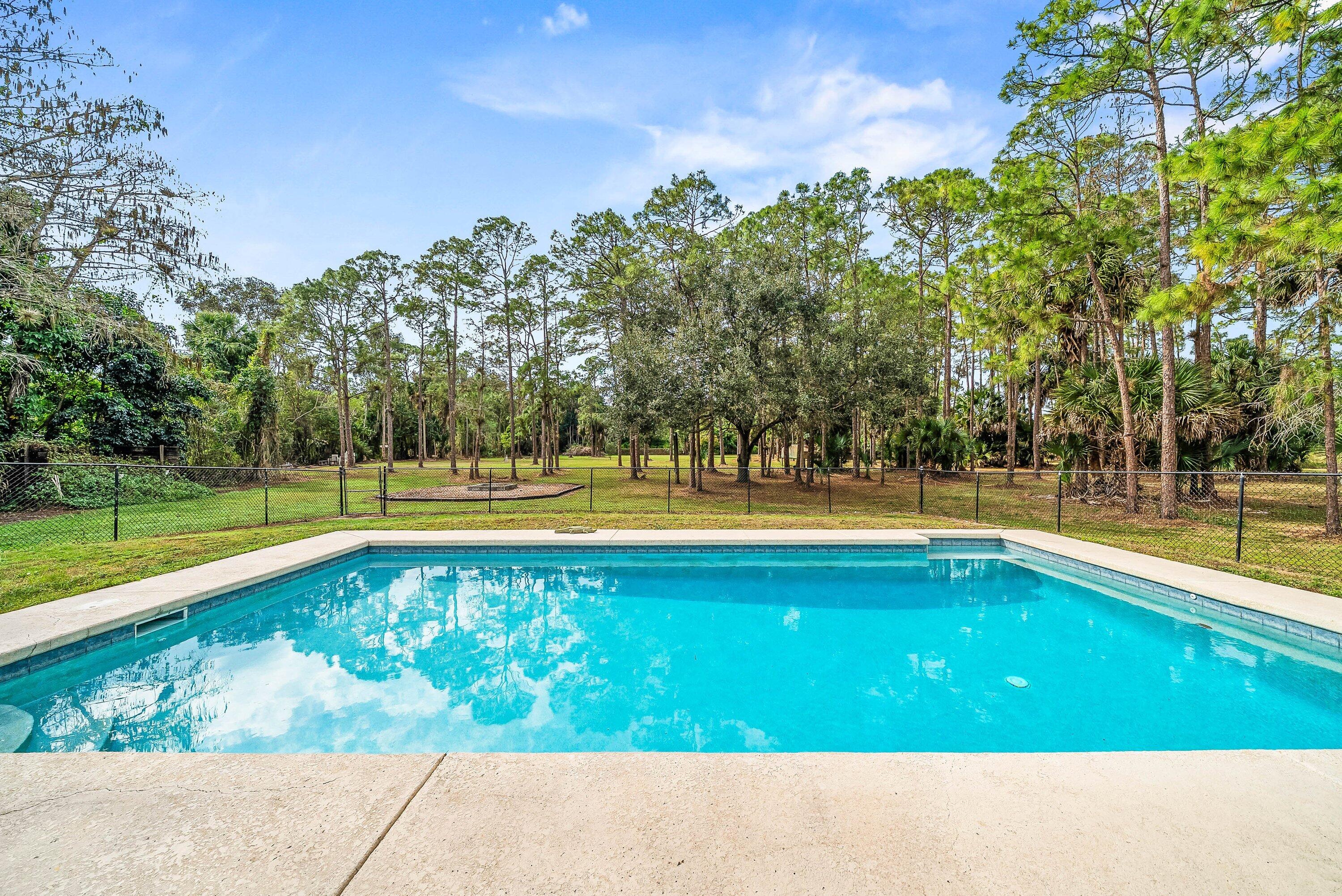 2195 F Road Loxahatchee Groves, FL 33470 - Photo 23 of 54 a view of a swimming pool and a yard