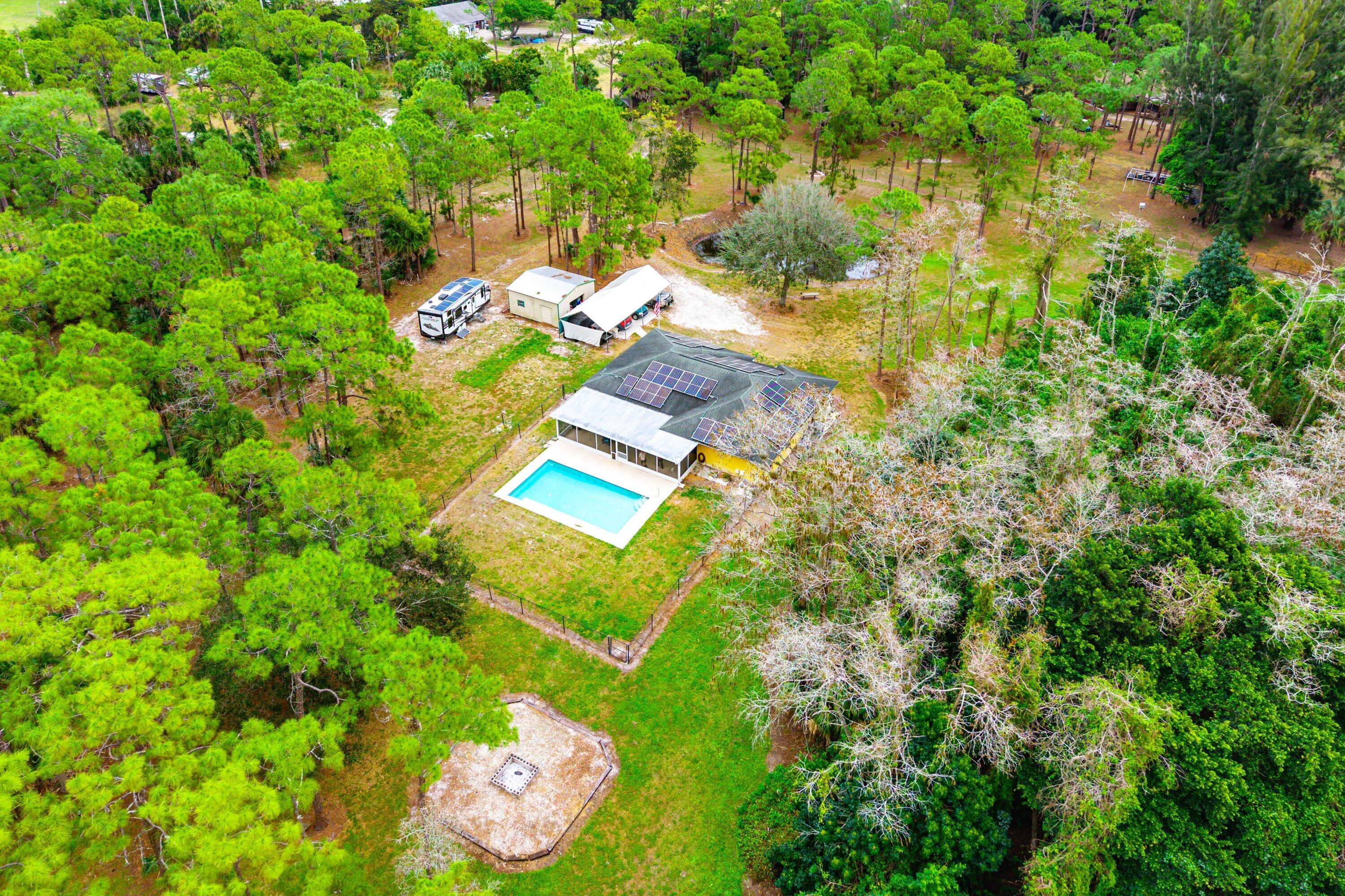 2195 F Road Loxahatchee Groves, FL 33470 - Photo 51 of 54 a view of swimming pool with a yard and large trees