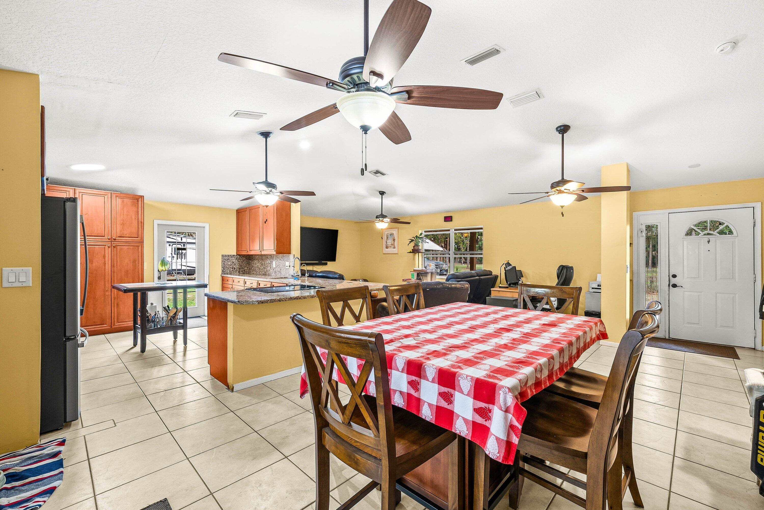 2195 F Road Loxahatchee Groves, FL 33470 - Photo 7 of 54 a dining area with a table chairs and a kitchen view