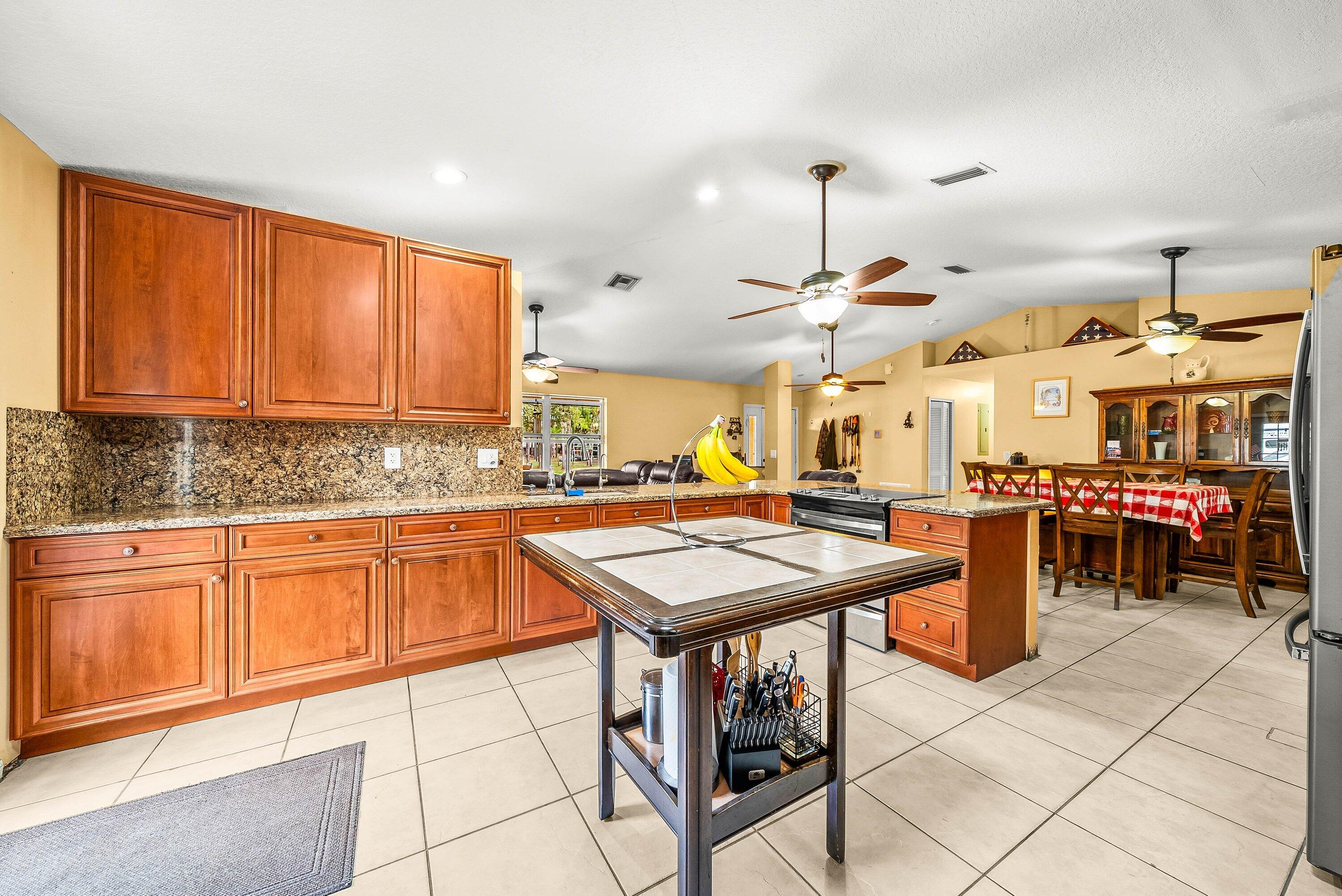 2195 F Road Loxahatchee Groves, FL 33470 - Photo 10 of 54 a kitchen with stainless steel appliances granite countertop a sink and cabinets
