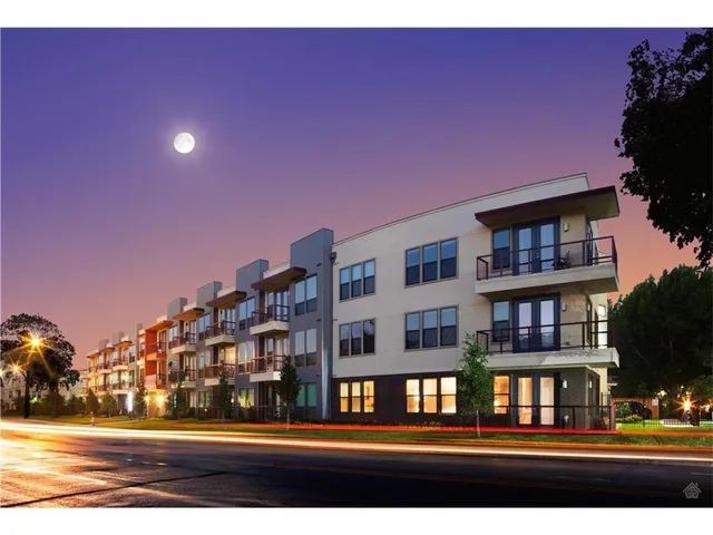 a front view of a multi story residential apartment building with a yard