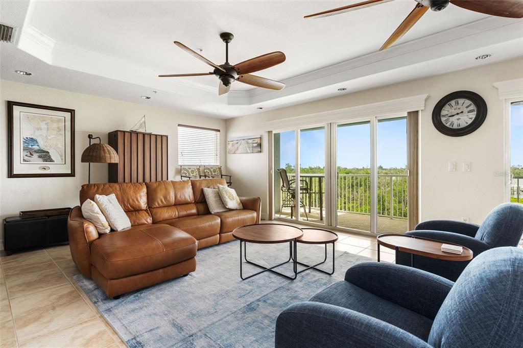1420 Beach Road, Unit 204 Englewood, FL 34223 - Photo 19 of 99 a living room with furniture a clock and a large window