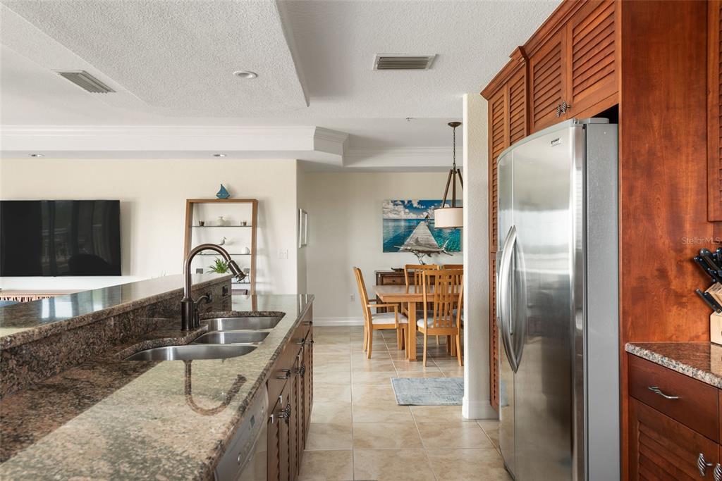 1420 Beach Road, Unit 204 Englewood, FL 34223 - Photo 30 of 99 a kitchen with stainless steel appliances granite countertop a refrigerator a stove and a sink with wooden floor