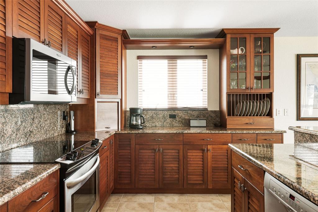 1420 Beach Road, Unit 204 Englewood, FL 34223 - Photo 31 of 99 a kitchen with granite countertop a sink and a stove