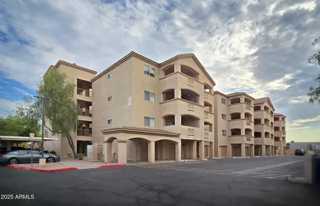 a front view of a building with lot of cars parked on road