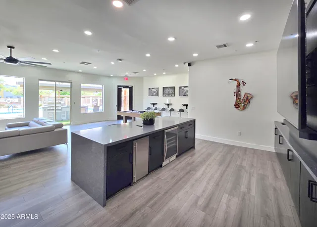 a large kitchen with stainless steel appliances granite countertop a large counter top a sink a stove and a refrigerator