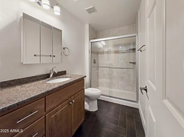 a bathroom with a granite countertop sink toilet and shower