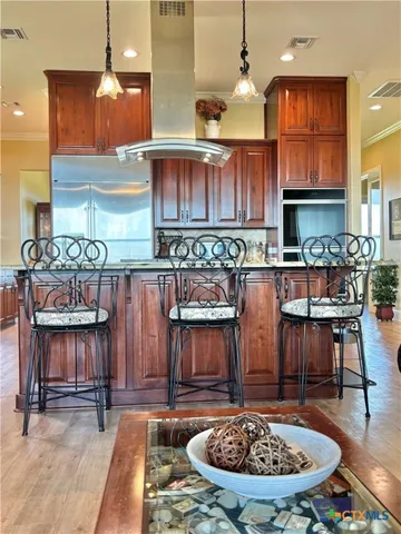 a kitchen with stainless steel appliances kitchen island granite countertop a stove and a sink