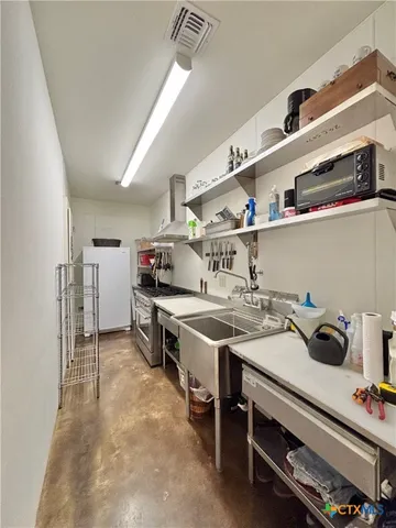 a kitchen with a stove and a wooden floor
