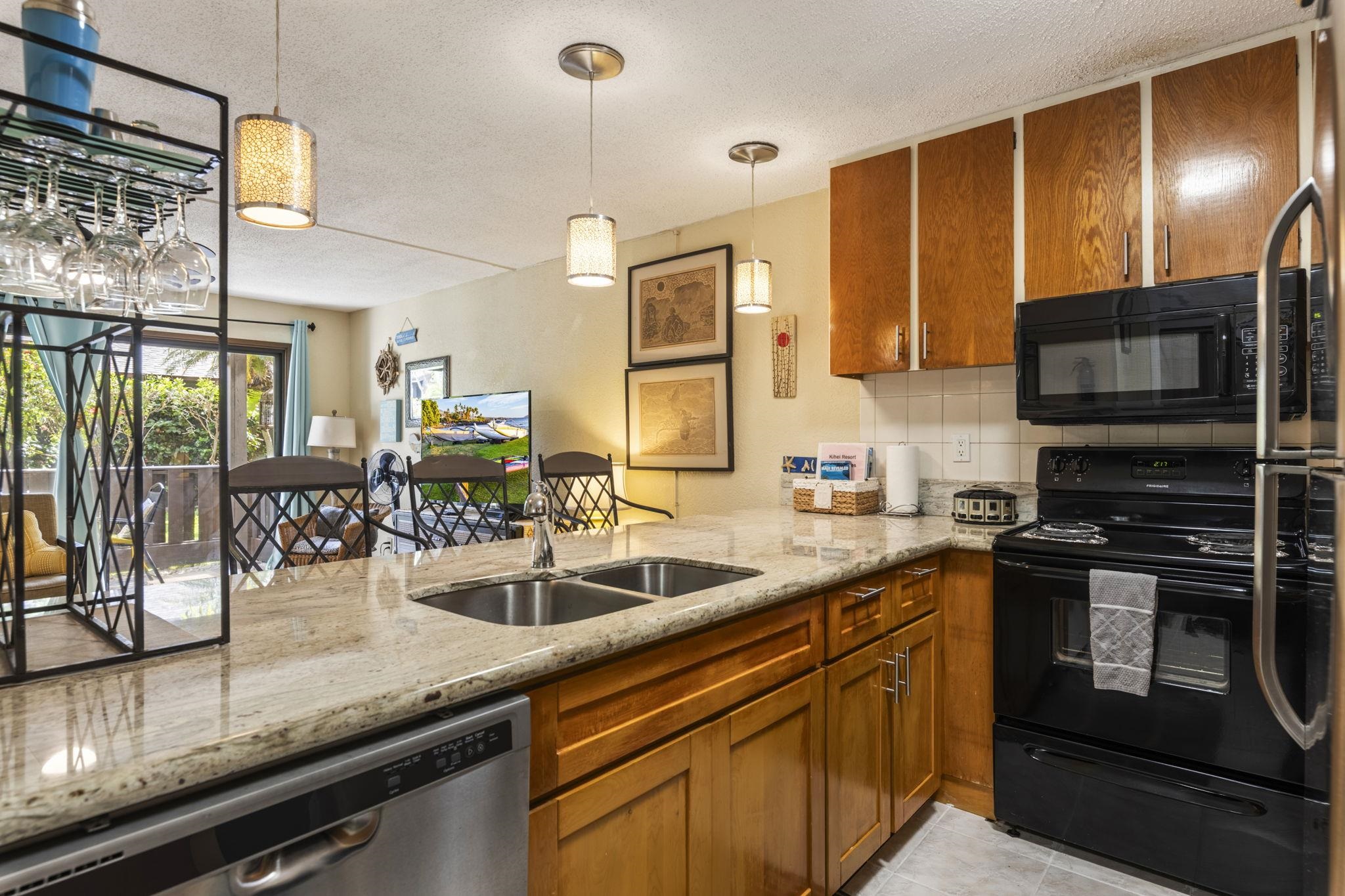 777 South Kihei Road, Unit 105 Kihei, HI 96753 - Photo 14 of 27 a kitchen with stainless steel appliances granite countertop a sink a stove counter space and cabinets