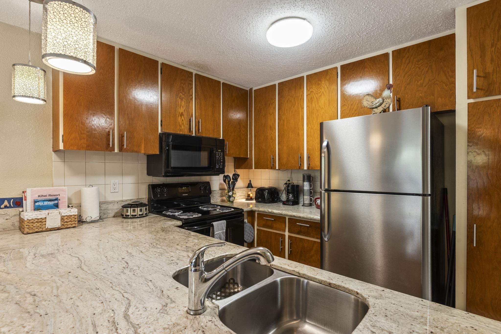 777 South Kihei Road, Unit 105 Kihei, HI 96753 - Photo 5 of 27 a kitchen with stainless steel appliances a refrigerator and a sink