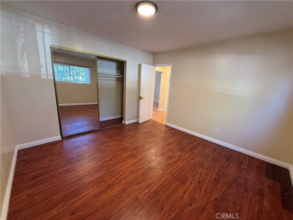 1805 South Rimpau Boulevard Los Angeles, CA 90019 - Photo 11 of 15 an empty room with wooden floor and windows