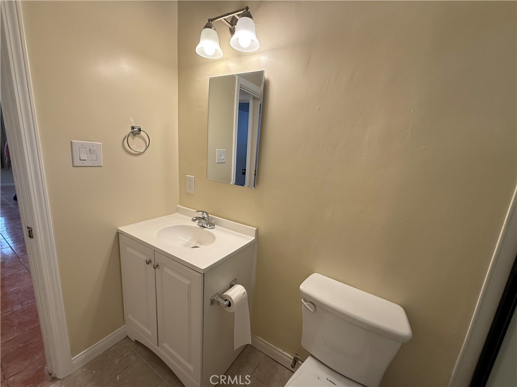 1805 South Rimpau Boulevard Los Angeles, CA 90019 - Photo 14 of 15 a bathroom with a toilet a sink and mirror