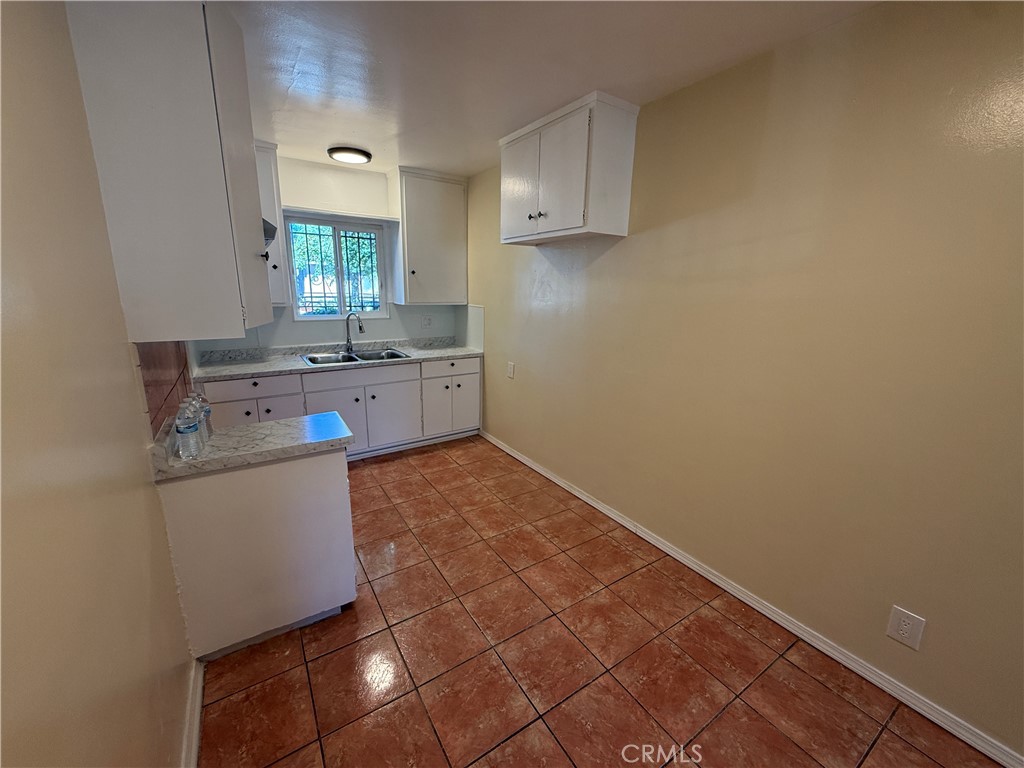 1805 South Rimpau Boulevard Los Angeles, CA 90019 - Photo 2 of 15 a kitchen with granite countertop a sink a stove cabinets and wooden floor