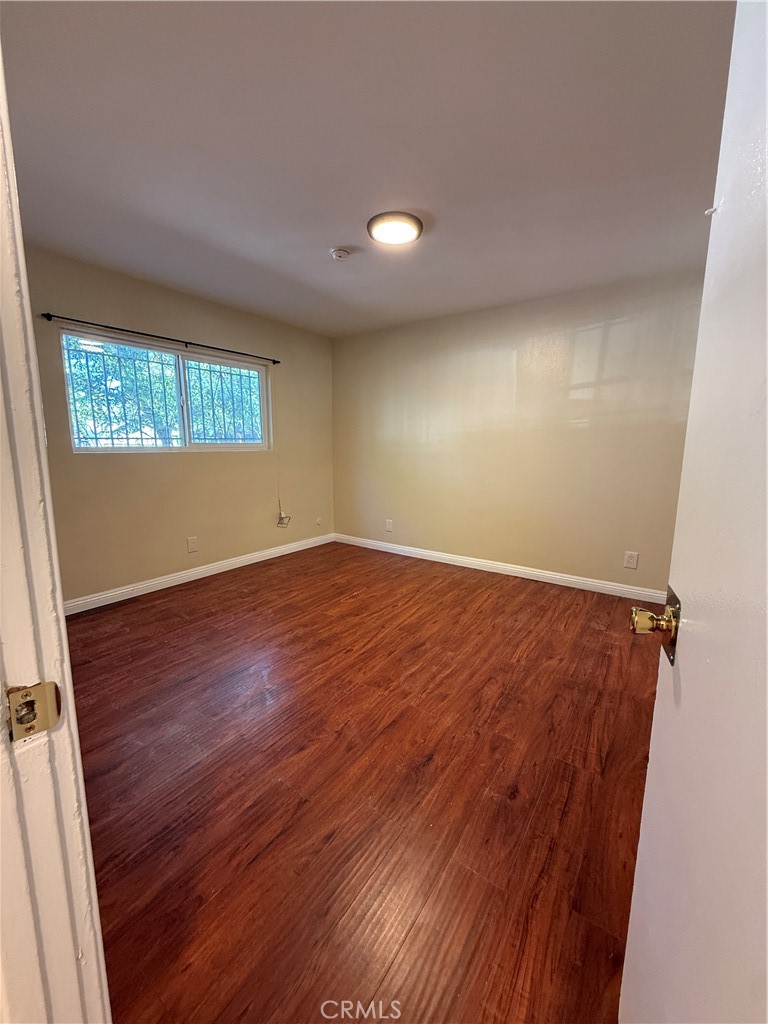 1805 South Rimpau Boulevard Los Angeles, CA 90019 - Photo 9 of 15 an empty room with wooden floor and windows