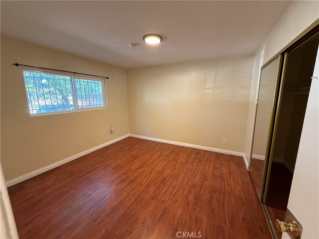 1805 South Rimpau Boulevard Los Angeles, CA 90019 - Photo 10 of 15 an empty room with wooden floor and windows