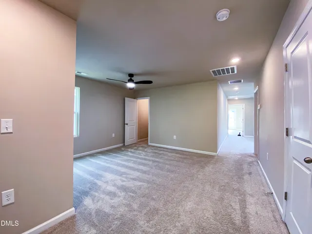 a view of hallway with a window and wooden floor