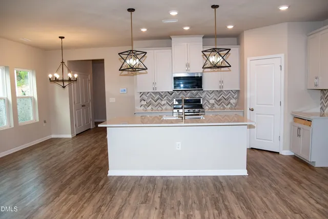 a kitchen with stainless steel appliances a stove top oven a sink and a refrigerator