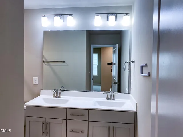 a view of an empty room with a chandelier fan