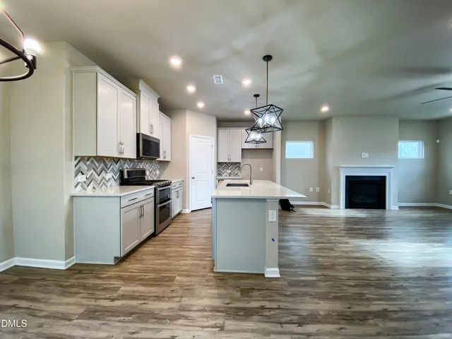 a kitchen with kitchen island a sink stainless steel appliances and cabinets