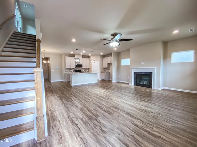 a kitchen with kitchen island granite countertop stainless steel appliances a sink cabinets and wooden floor