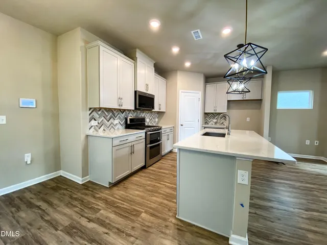 a view of a kitchen with a sink dishwasher and a fireplace