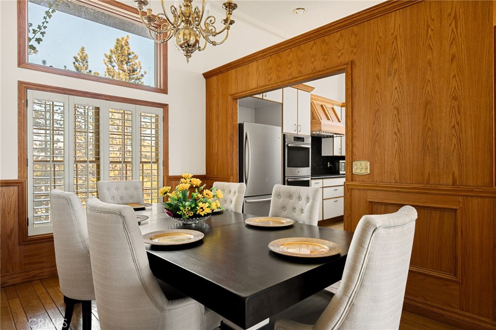 971 Grass Valley Road Lake Arrowhead, CA 92352 - Photo 22 of 50 a view of a dining room with furniture a chandelier and wooden floor
