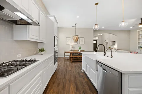 a kitchen with kitchen island a sink and a stove with wooden floor