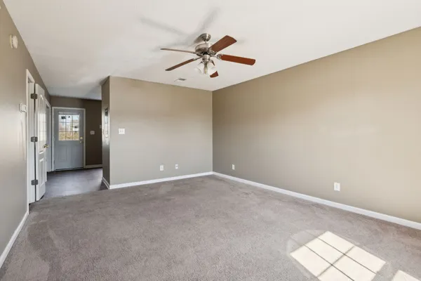 an empty room with closet and a chandelier fan