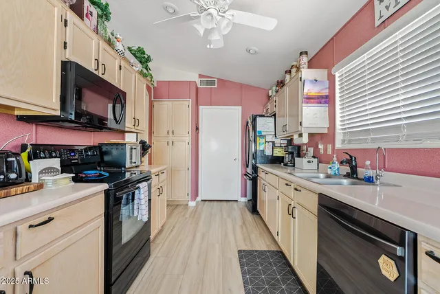 a kitchen with stainless steel appliances a stove top oven a sink dishwasher and a refrigerator with wooden floor