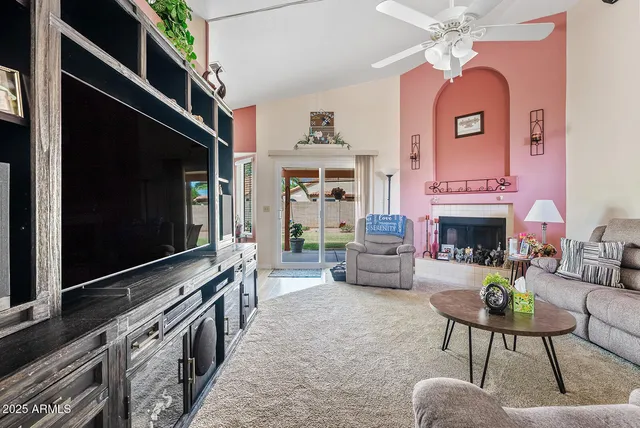 a living room with furniture a fireplace and a flat screen tv