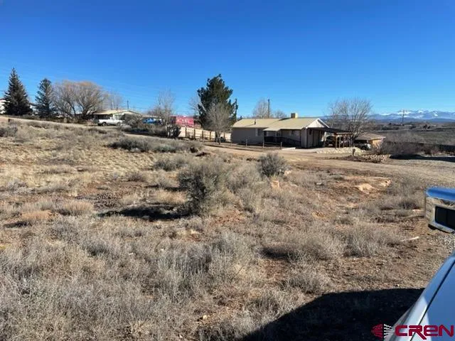 a view of dirt road with a building in the background