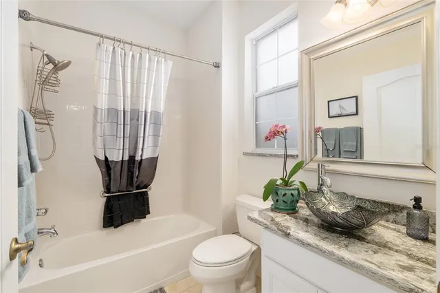 a bathroom with a granite countertop sink a toilet and a bathtub