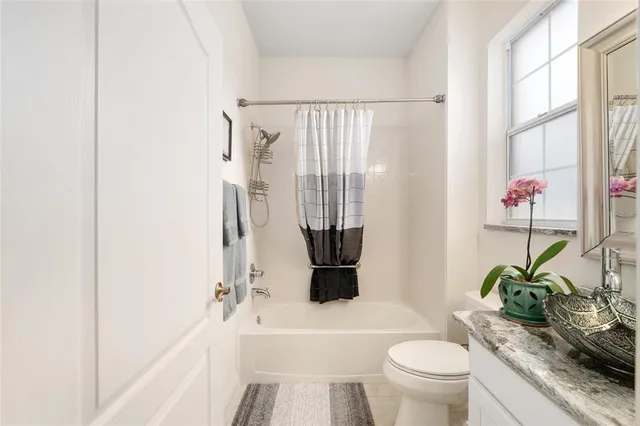 a bathroom with a granite countertop sink a toilet and shower