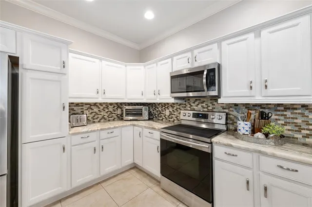 a kitchen with white cabinets and white appliances