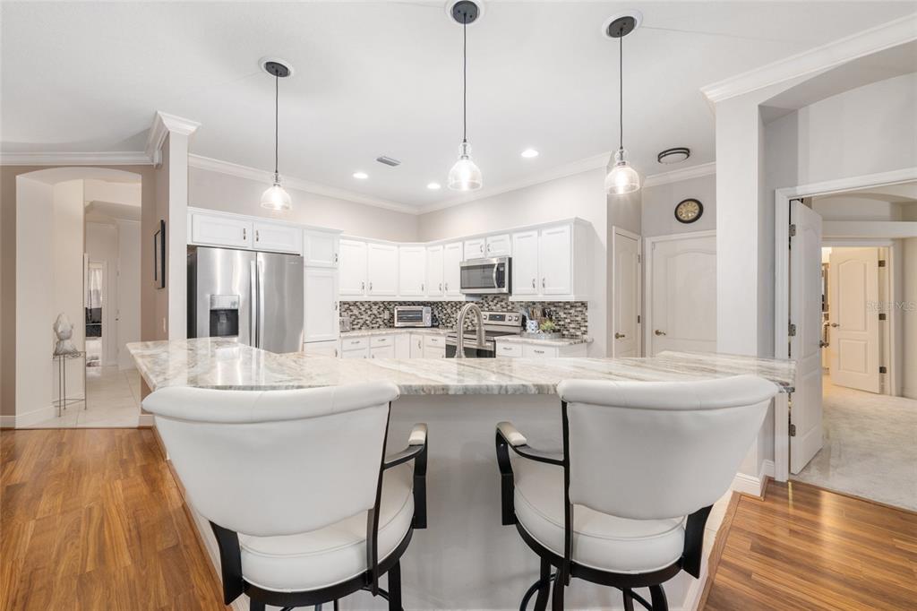 879 Chapman Loop The Villages, FL 32162 - Photo 9 of 34 a kitchen with kitchen island a white table and chairs