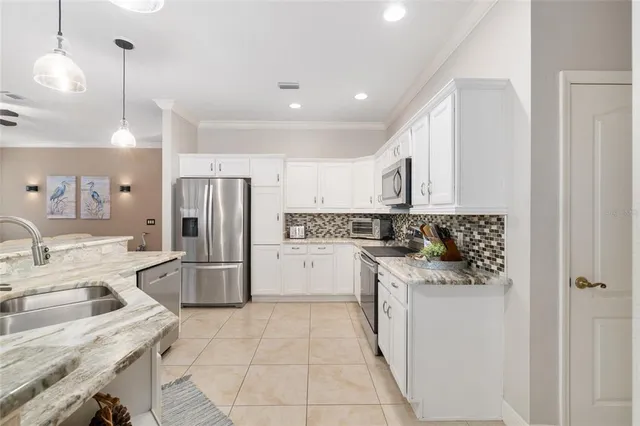 a kitchen with a sink a refrigerator and cabinets