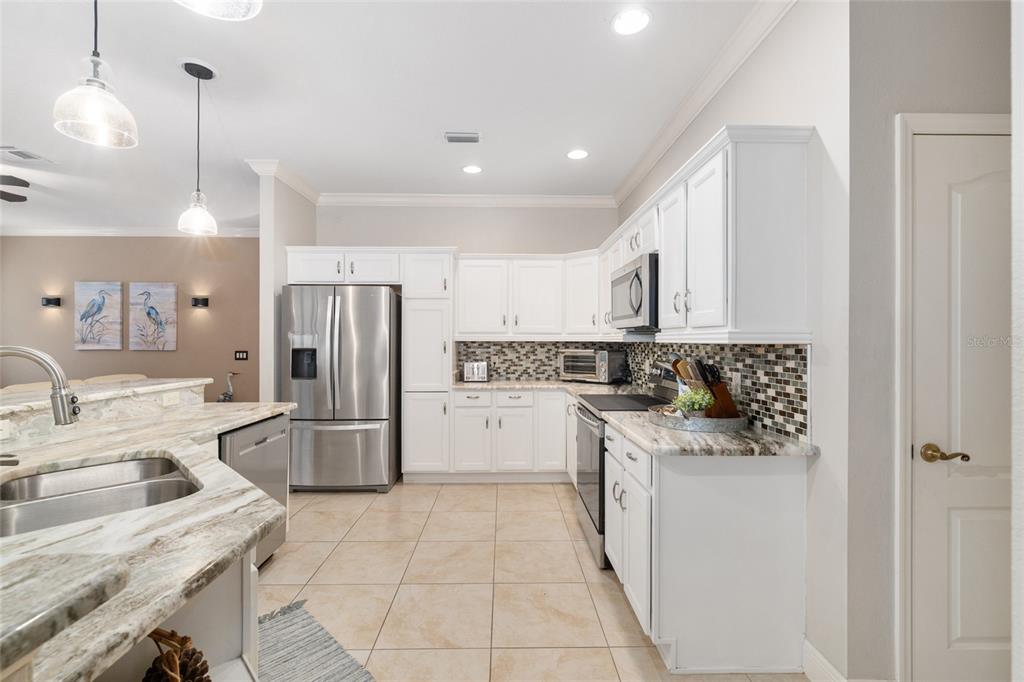 879 Chapman Loop The Villages, FL 32162 - Photo 10 of 34 a kitchen with a sink a refrigerator and cabinets