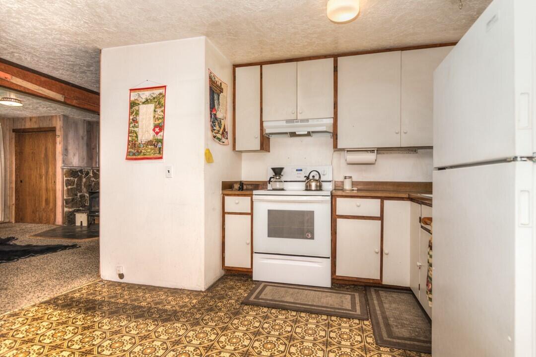 17026 Torrance Road Bend, OR 97707 - Photo 16 of 27 a kitchen with a stove a sink and a refrigerator