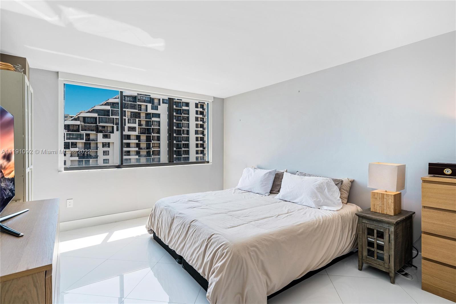 540 Brickell Key Drive, Unit 1427 Miami, FL 33131 - Photo 8 of 16 a bedroom with a large bed and a window