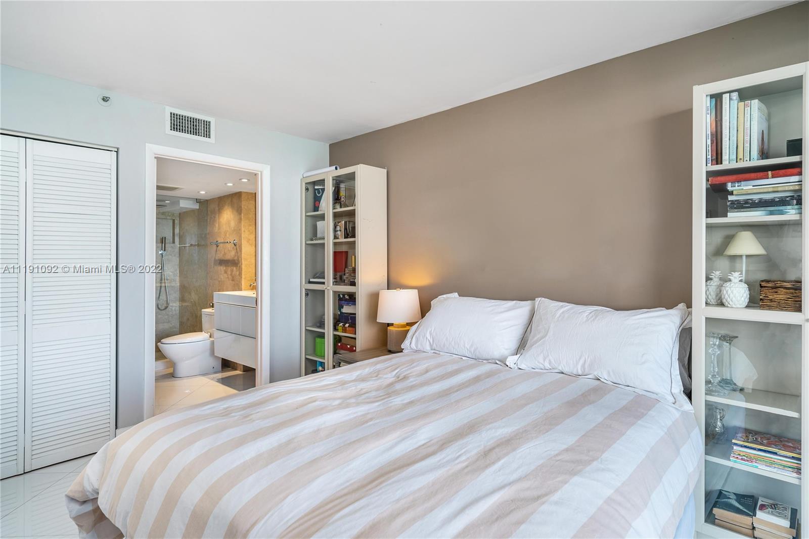 540 Brickell Key Drive, Unit 1427 Miami, FL 33131 - Photo 10 of 16 a bedroom with a bed and walk in closet