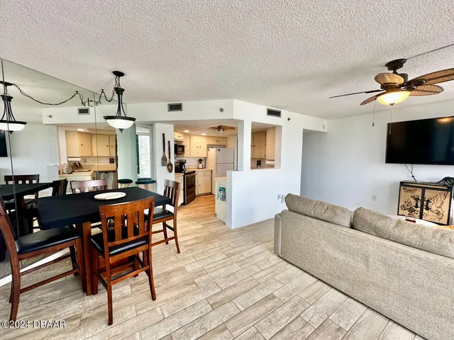 a living room with furniture a flat screen tv and kitchen view