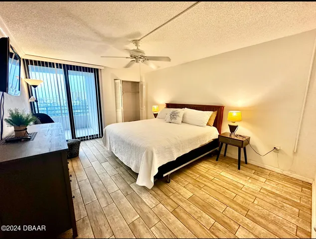 a bedroom with a bed lamps and a large mirror on the dresser