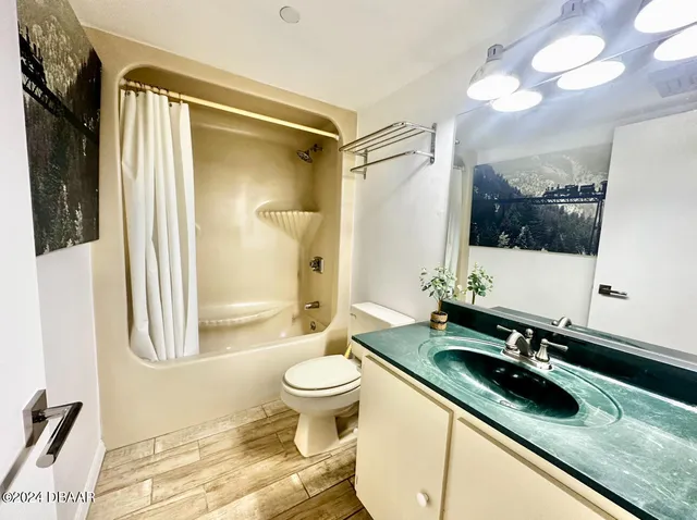 a bathroom with a sink a toilet a mirror and shower
