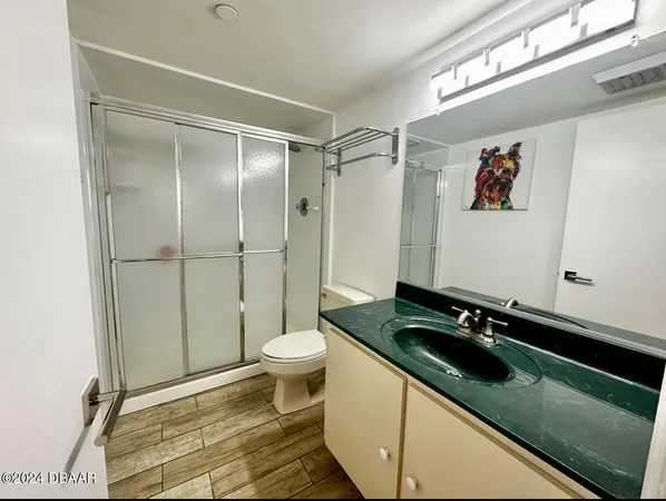 a bathroom with a granite countertop sink mirror vanity and toilet