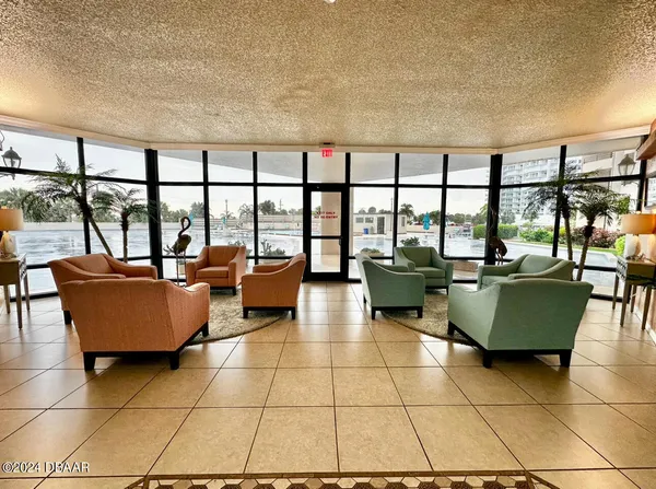 a living room with furniture and a floor to ceiling window