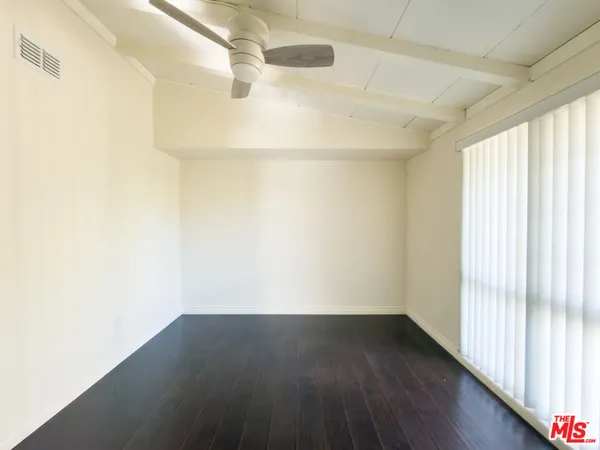 a view of a small space with wooden floor and a window